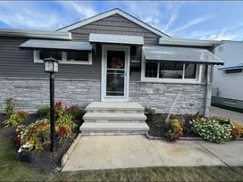 Home exterior with stone front entry and new siding